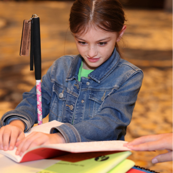 Young girl reads a Braille book