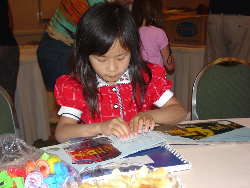 A young girls reads from a Braille book.
